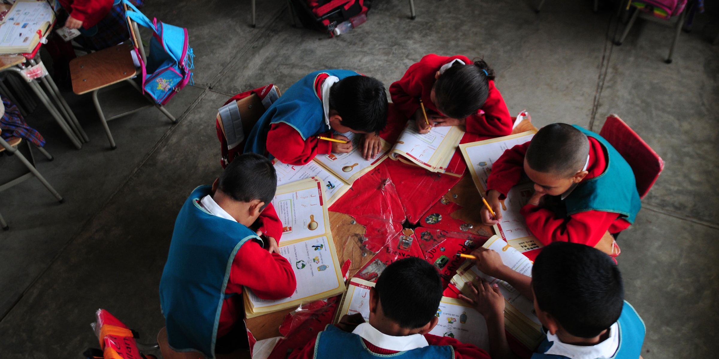 "Children work in their classroom in El Renacimiento school, in Villa Nueva, Guatemala. Credit: Maria Fleischmann / World Bank"